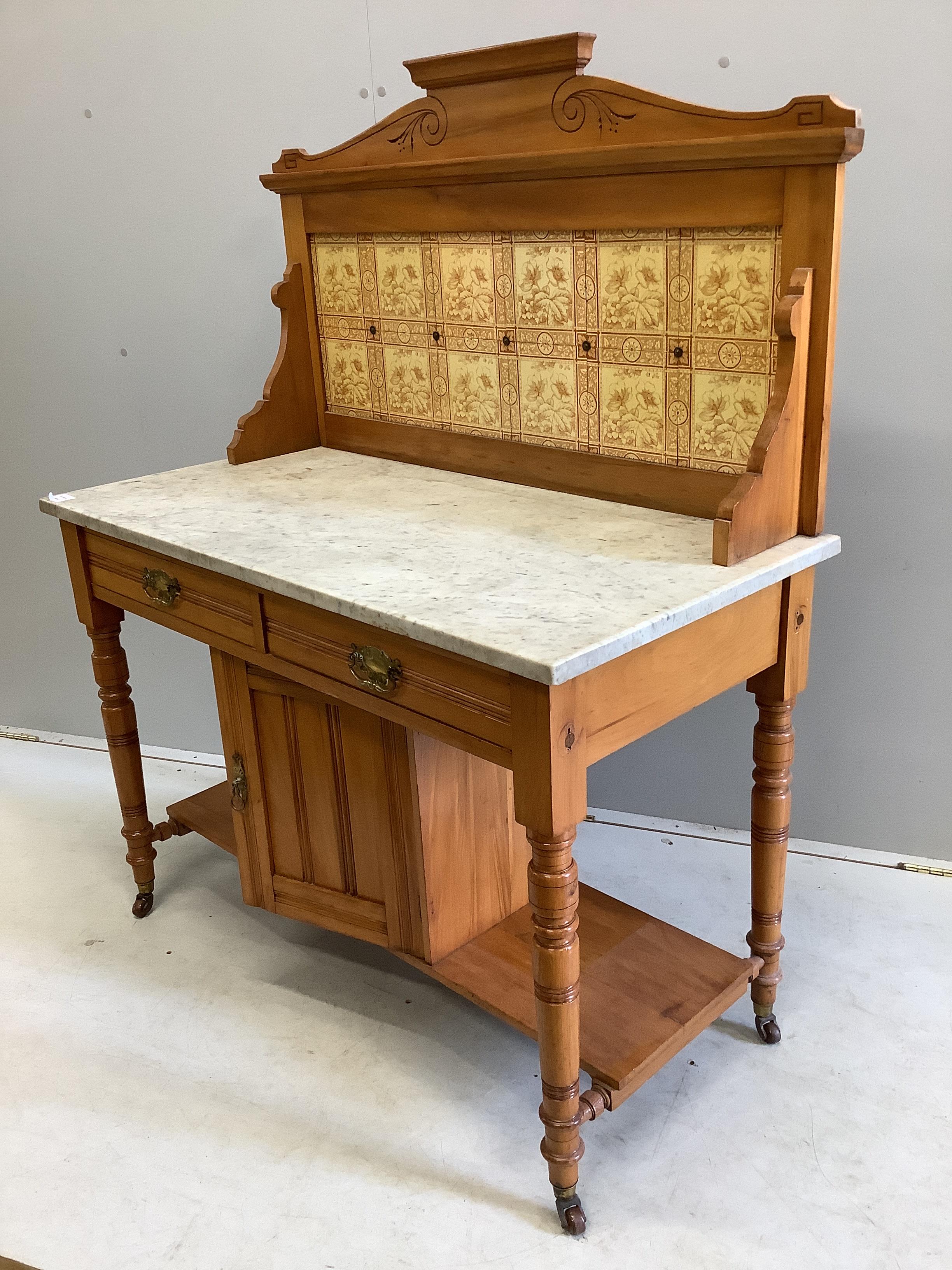 A late Victorian satin walnut tiled back marble top washstand, width 106cm, depth 52cm, height 133cm
